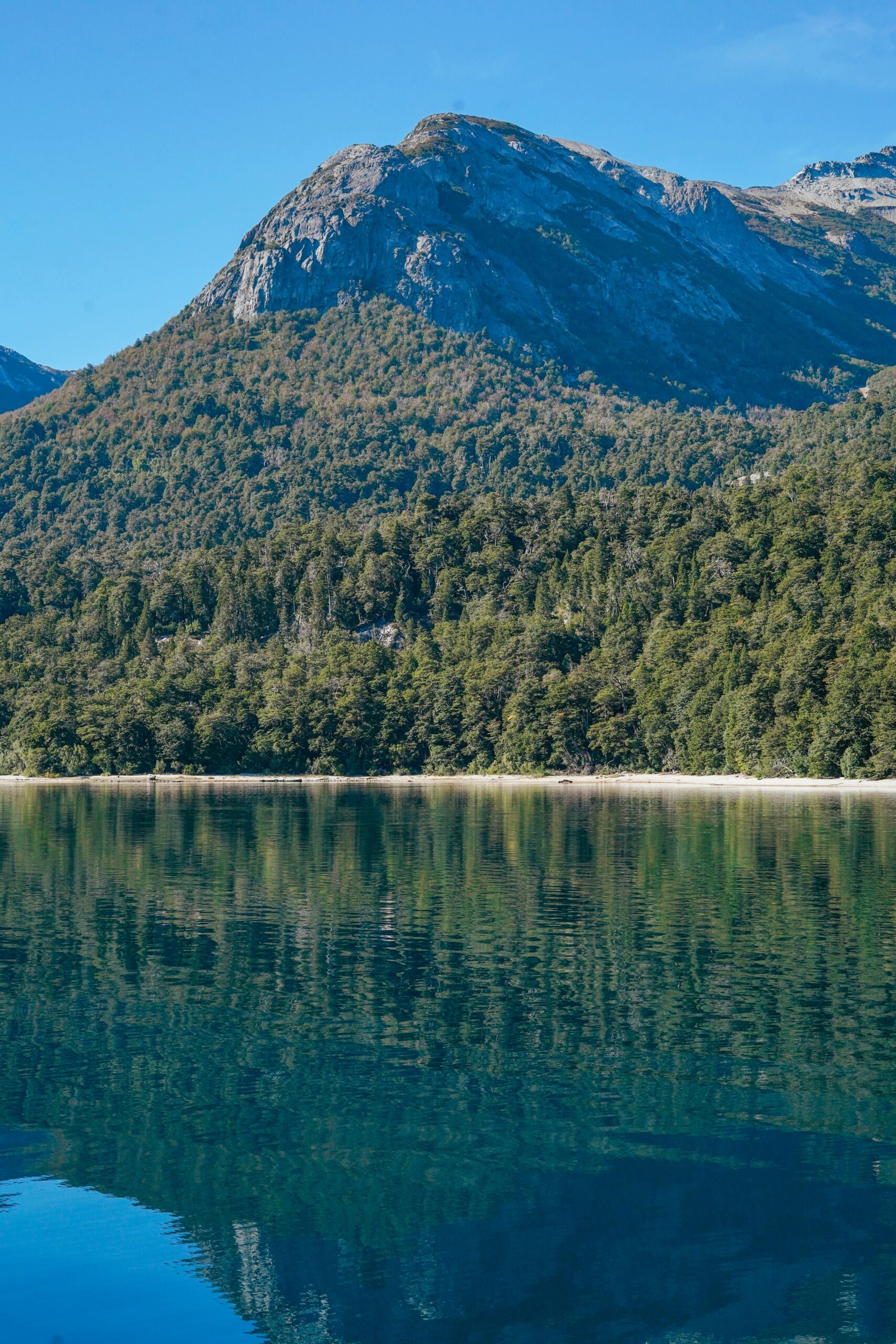 Breathtaking view of mountains and lake in Bariloche, Argentina, under clear blue skies.