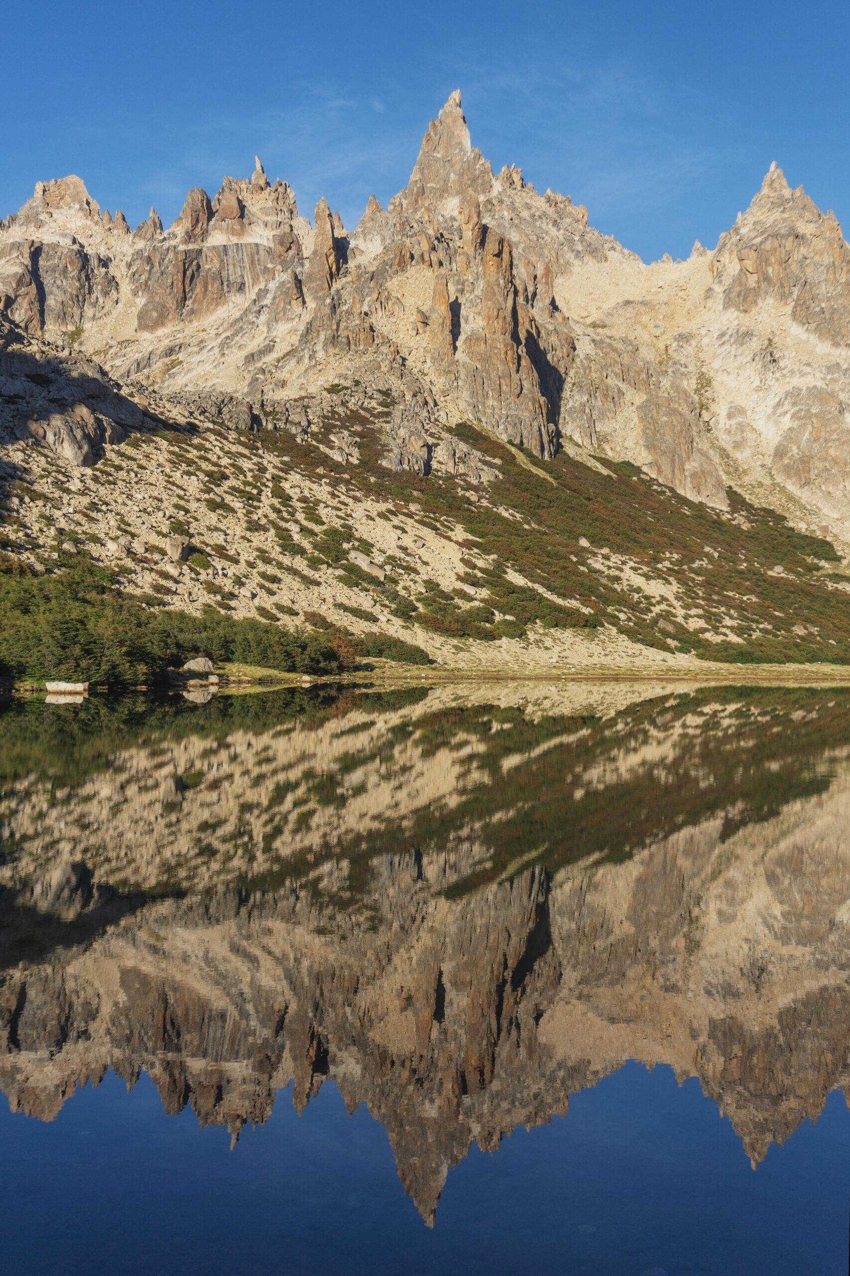 Breathtaking view of Cerro Catedral's reflection in a serene lake in Bariloche, Argentina.