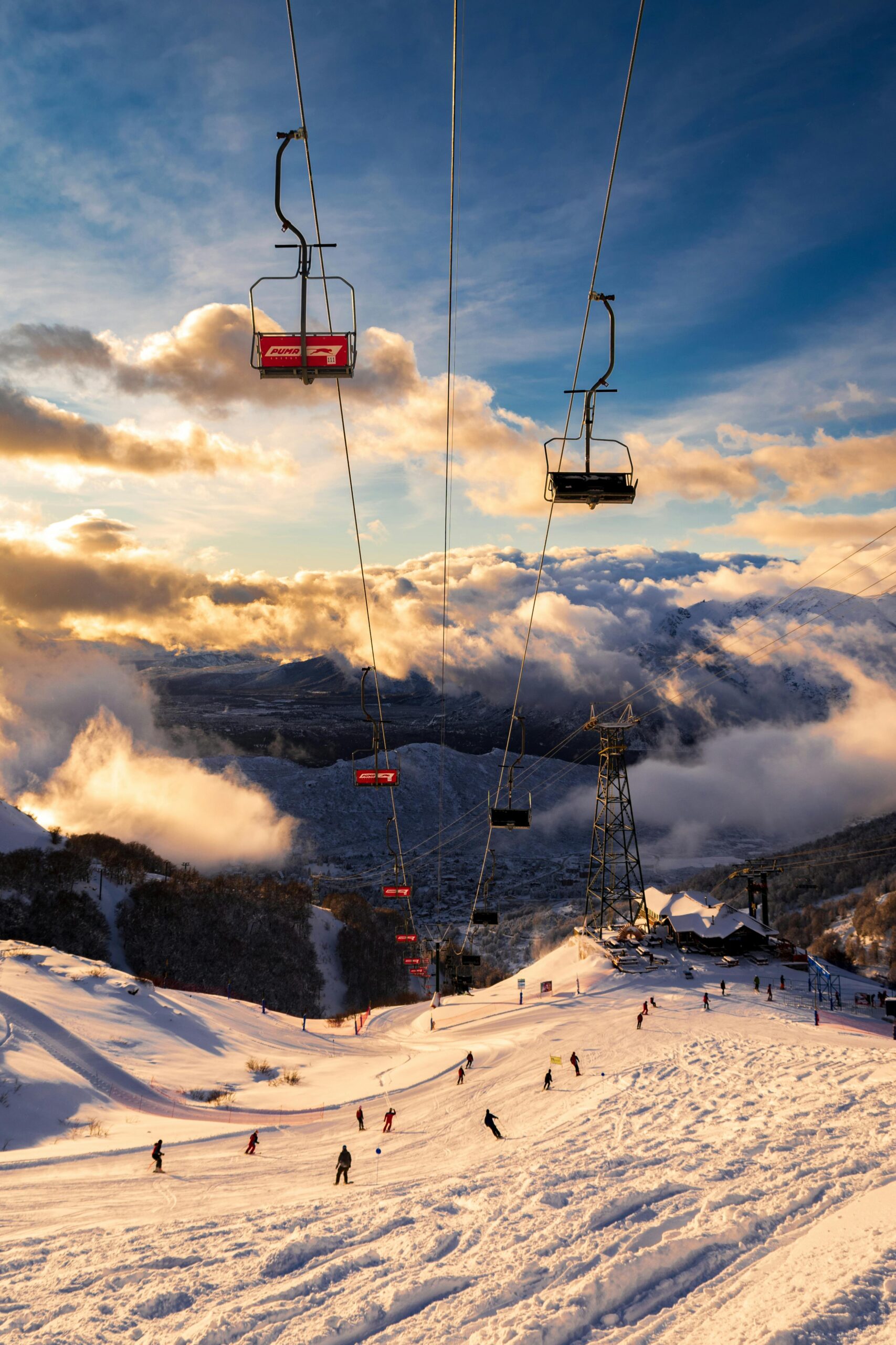 Skiers enjoying stunning winter sunset on the slopes of Bariloche, Argentina.